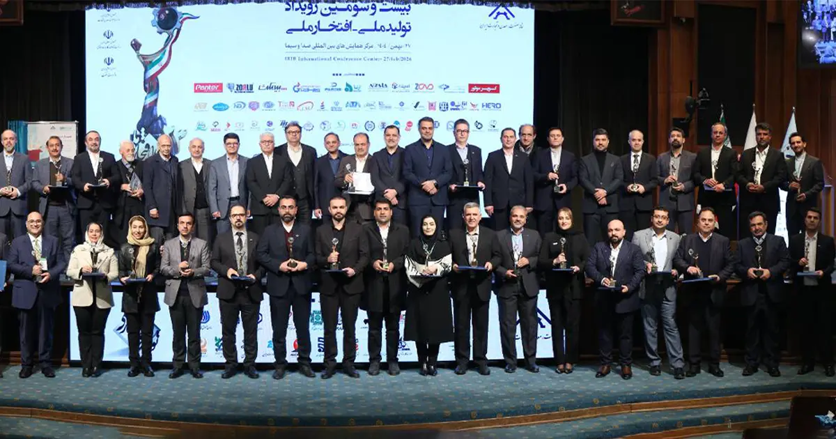 تعدادی از افراد در کنار یکدیگر ایستاده اند و تندیسی در دستشان دارند.